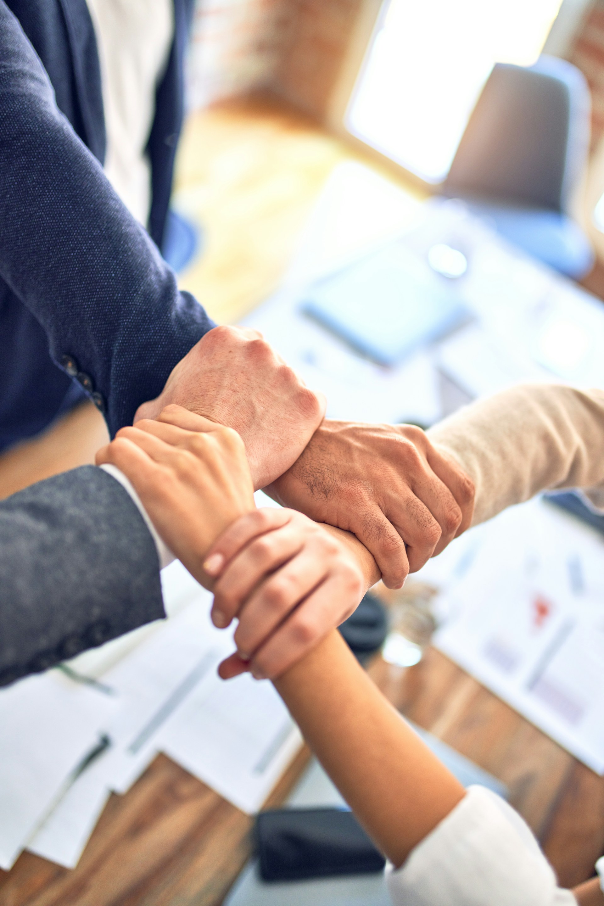 Groupe de mains se rejoignant pour symboliser la collaboration et le travail d'équipe dans un environnement professionnel.